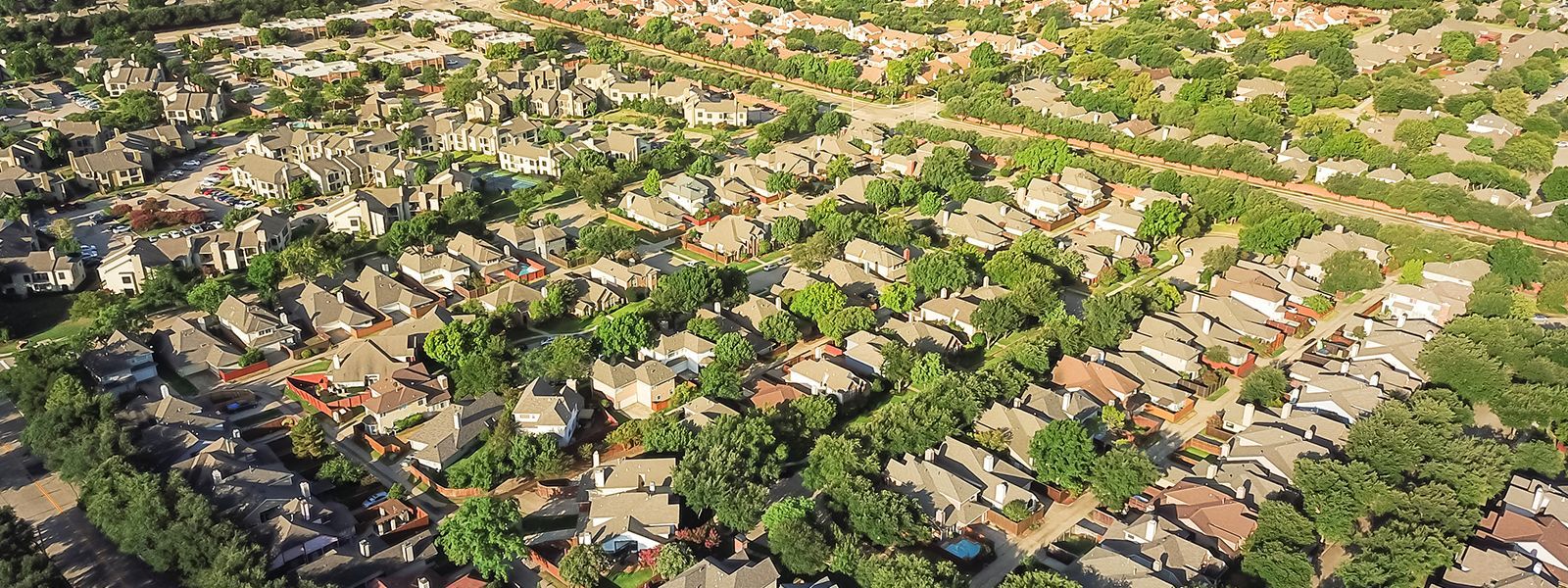 An aerial view of a residential area filled with lots of trees and houses.