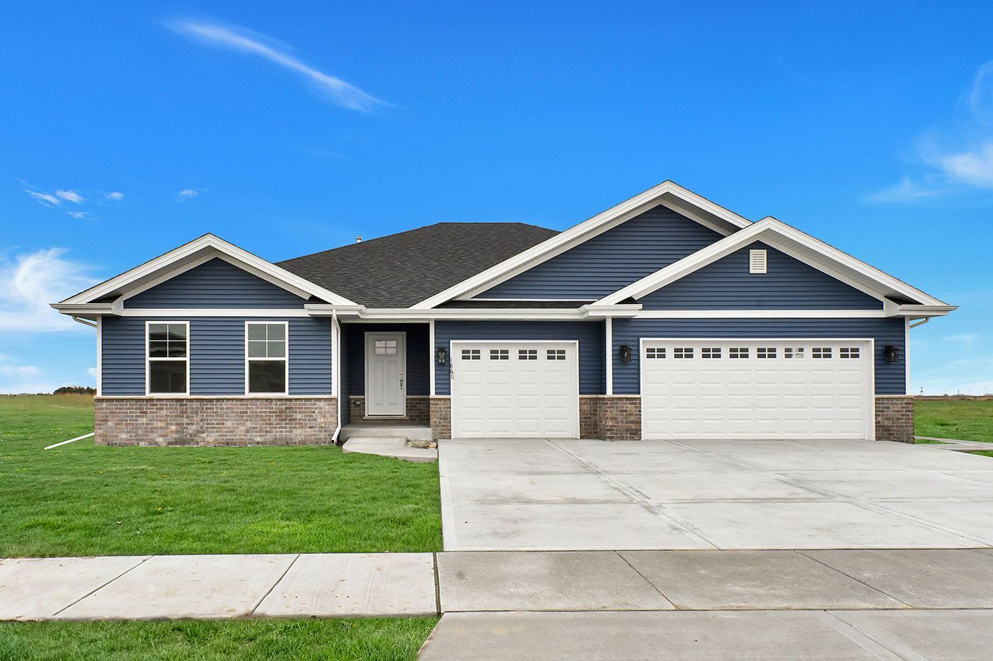 A blue house with white trim and a white garage door.
