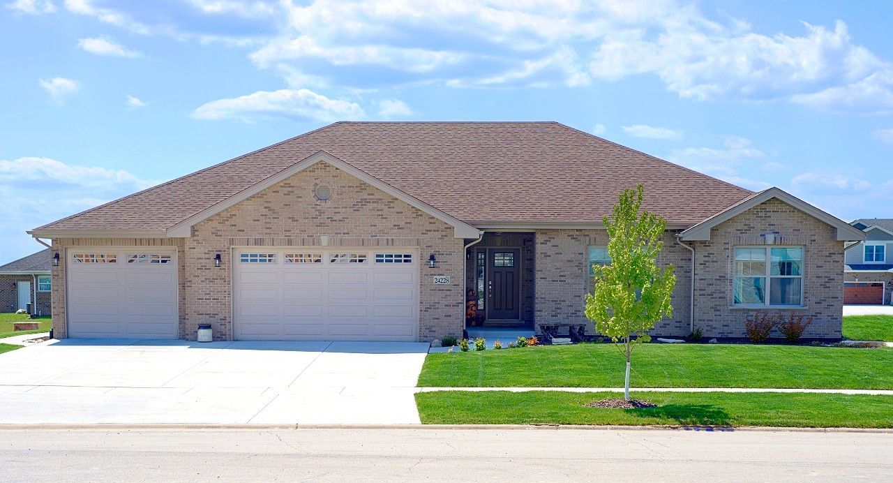A large brick house with a tan garage door.