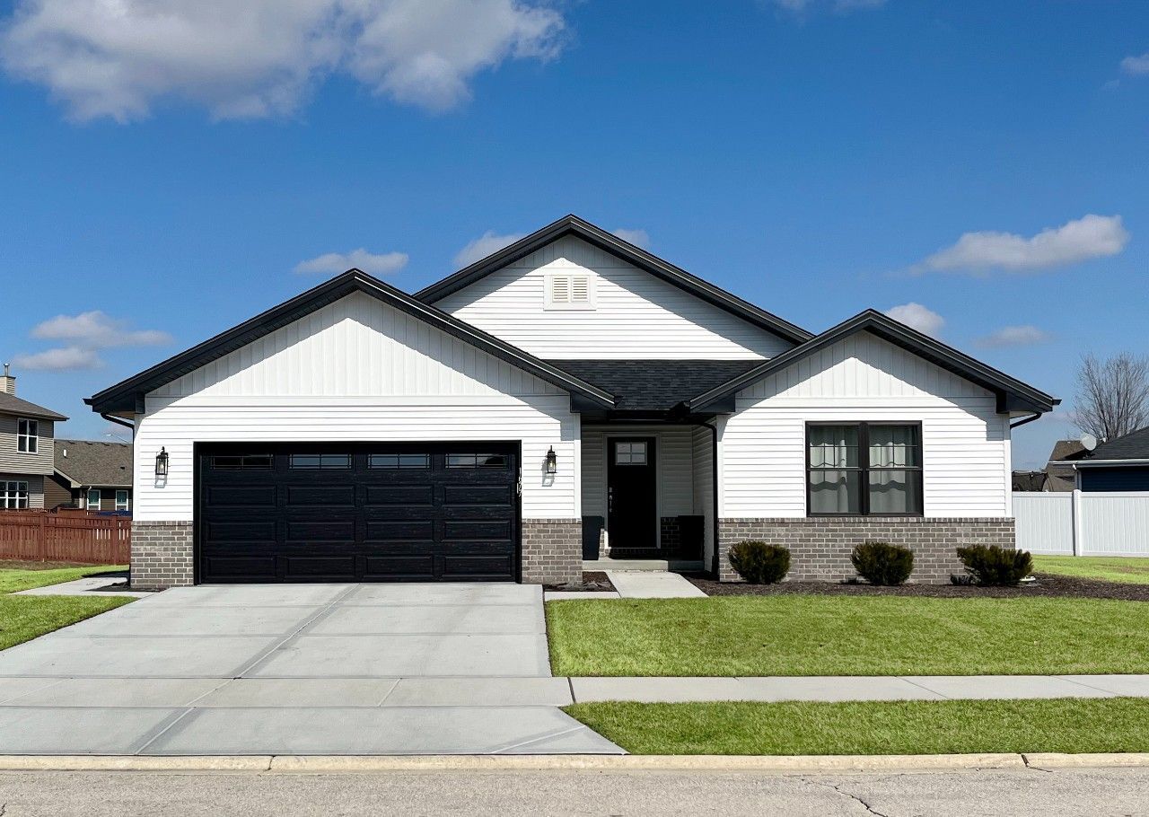 A white and black house with a black garage door