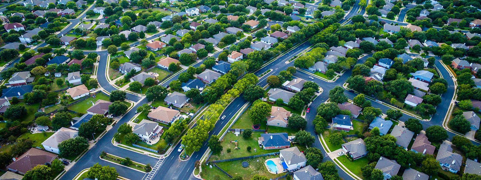 An aerial view of a residential neighborhood filled with lots of houses and trees.