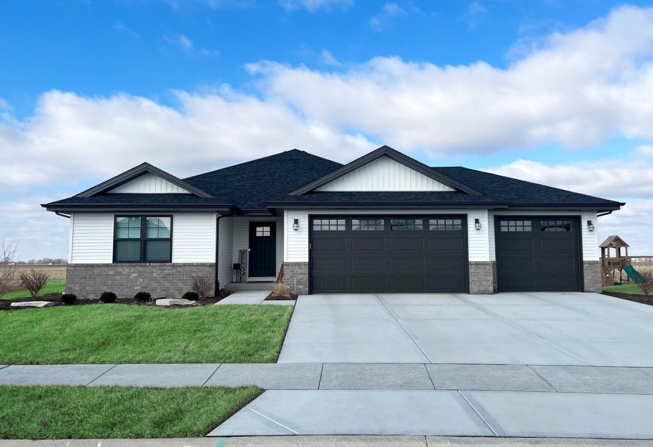 A white and black house with a black garage door.
