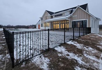 A large house with a black fence in front of it.