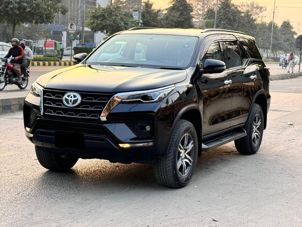Black Toyota Fortuner SUV parked on a city street.