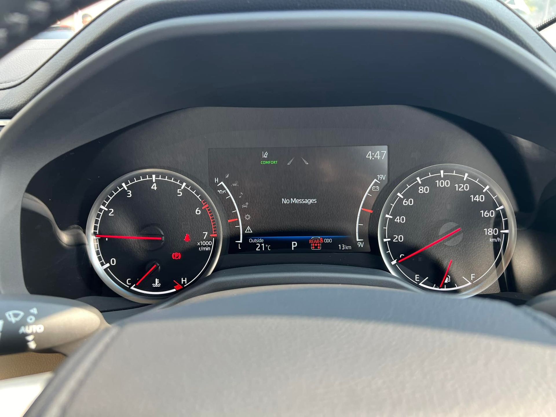 Car dashboard with gauges, speedometer, and digital display showing information and warning lights.