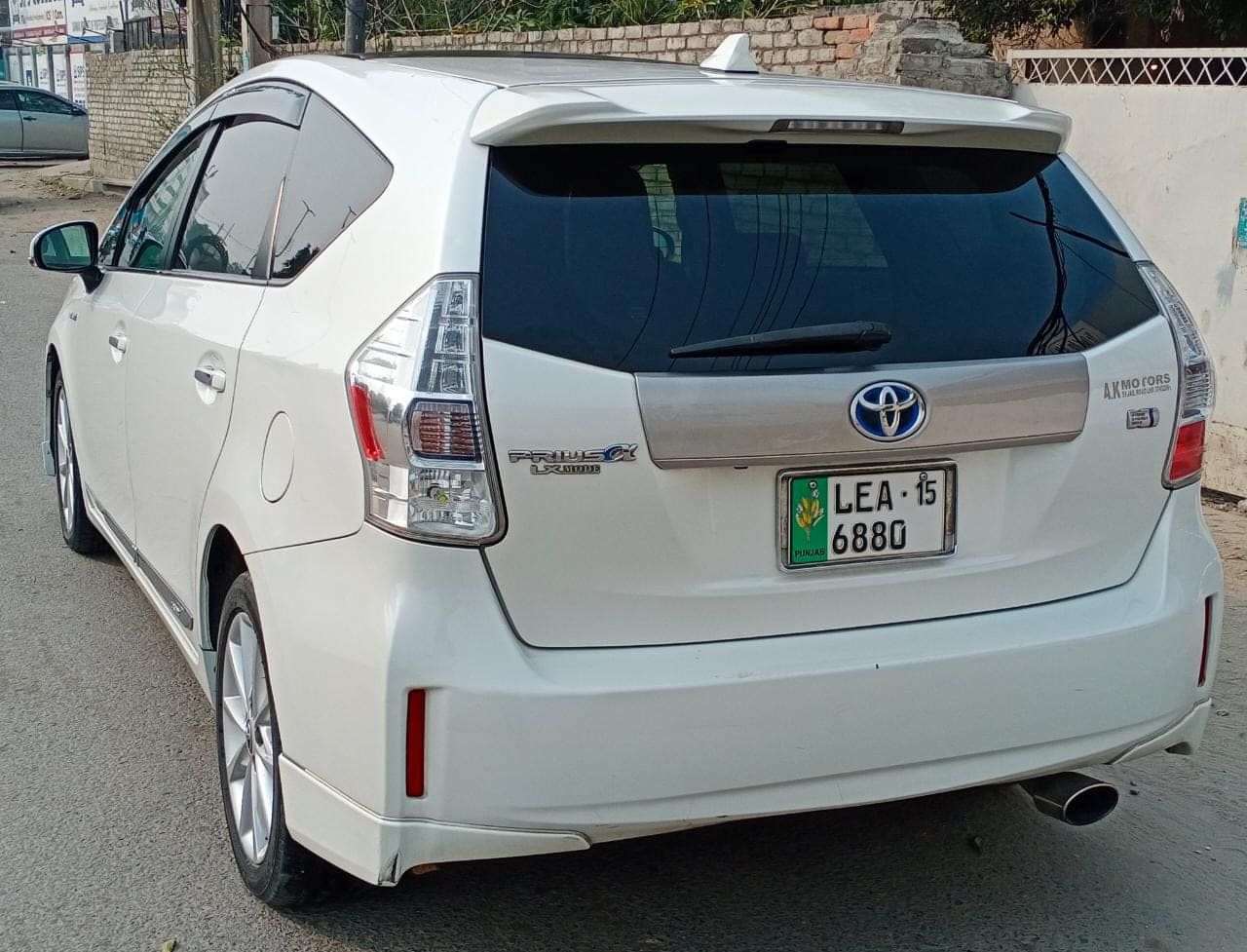 White Toyota Prius, rear view, license plate visible, parked on a street.