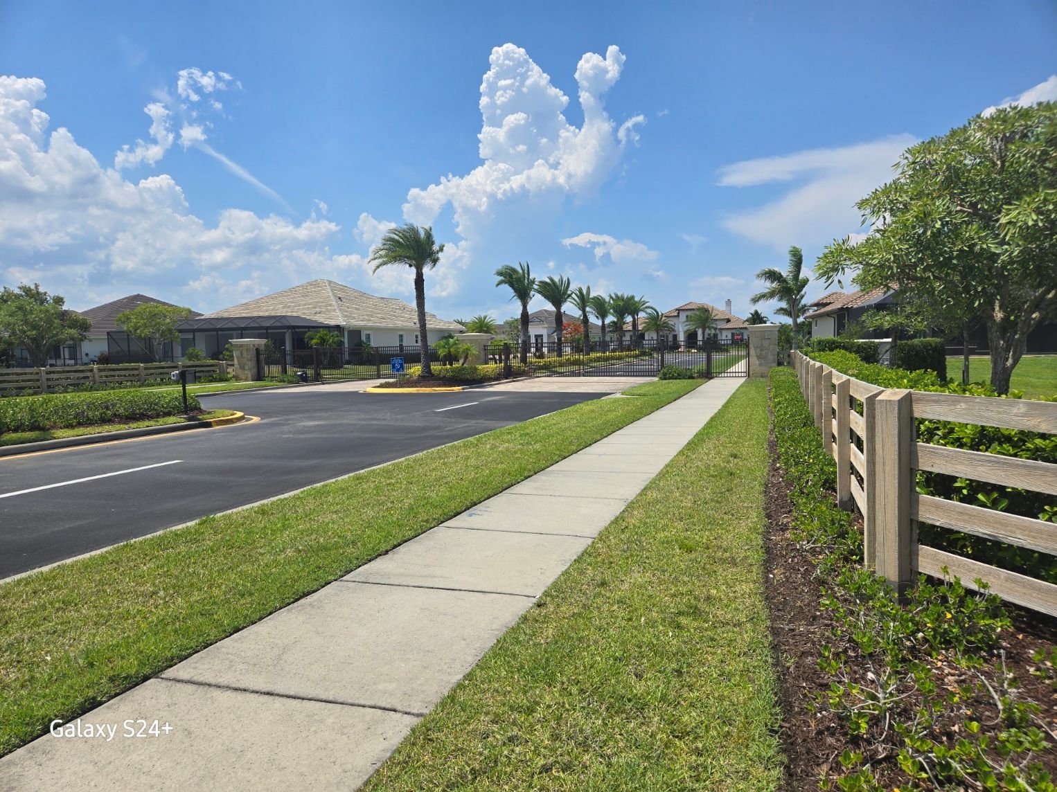 A sidewalk with a wooden fence along the side of it