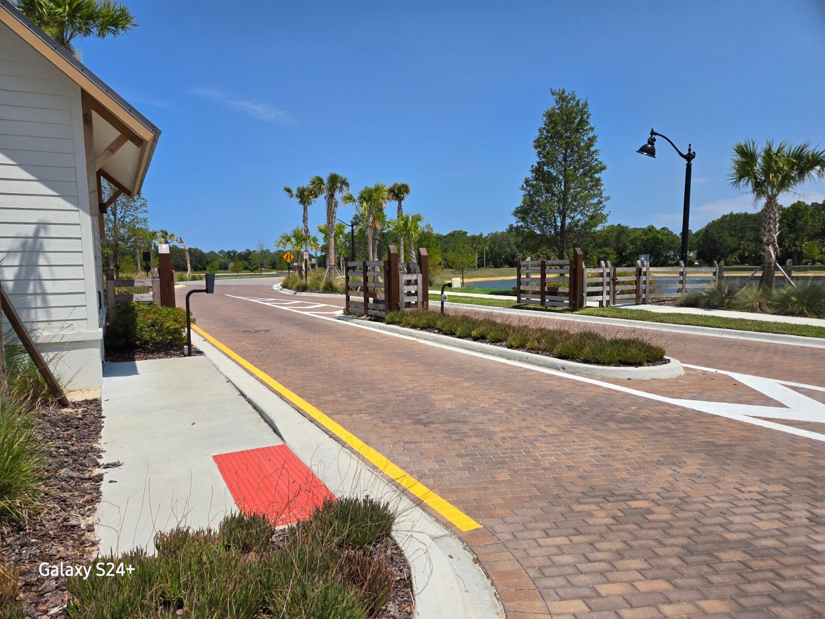 A brick road with a yellow line on the side of it.
