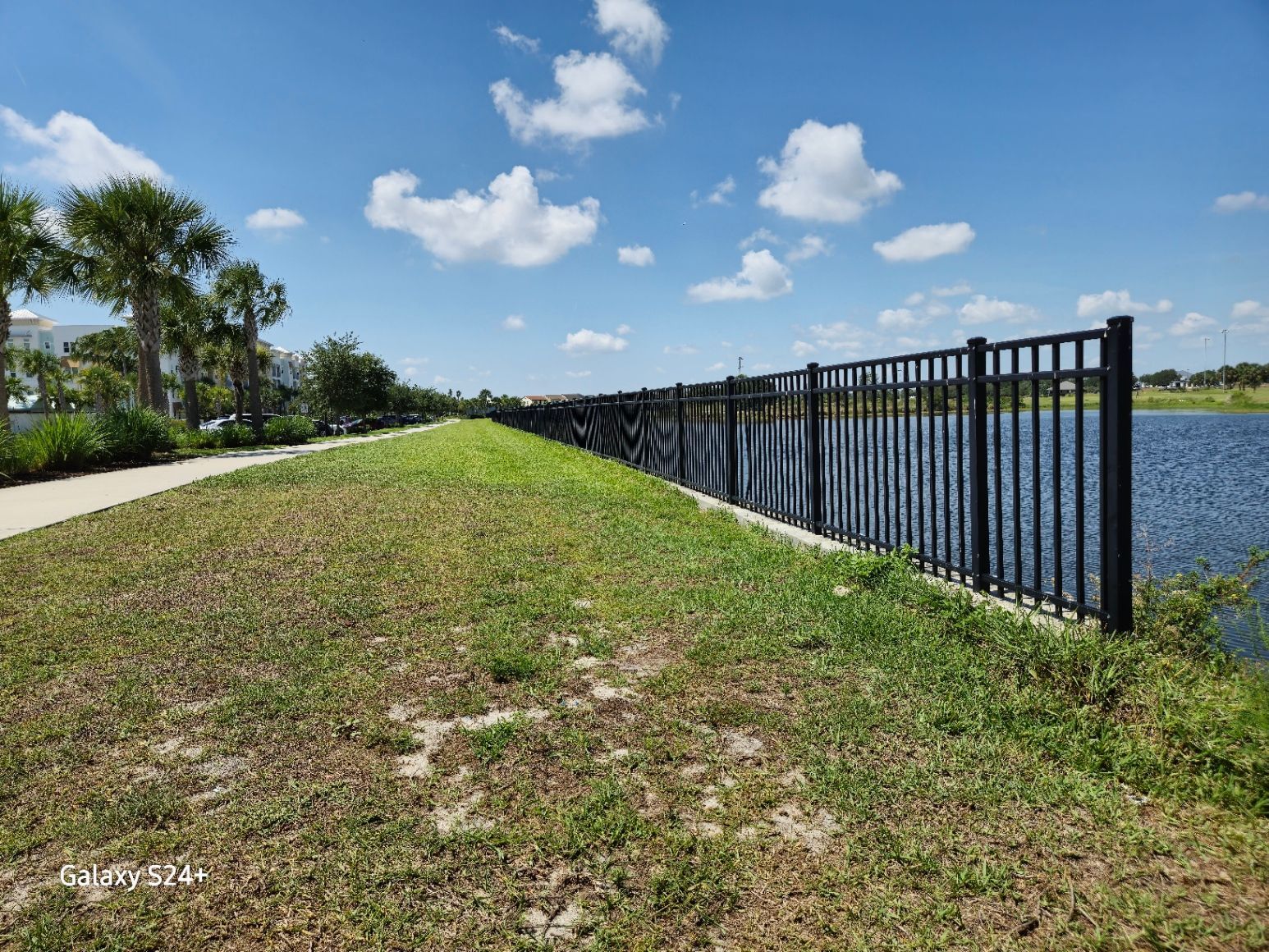 A fence along a path next to a body of water