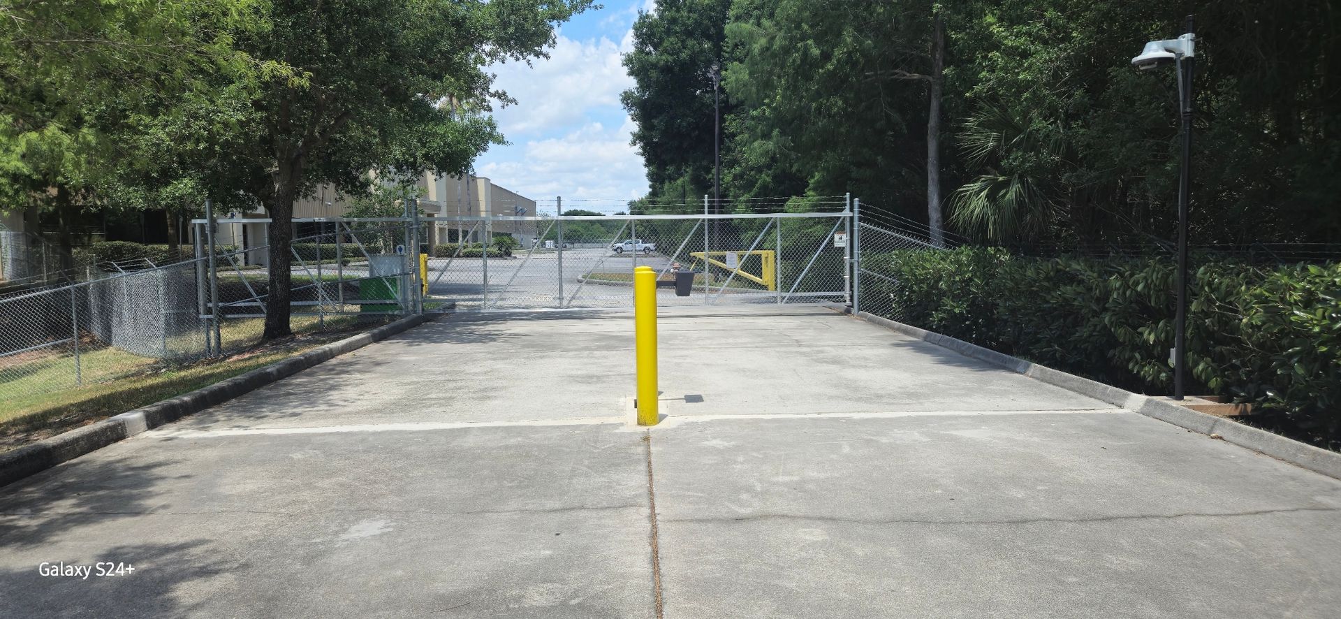 There is a yellow pole in the middle of the road.