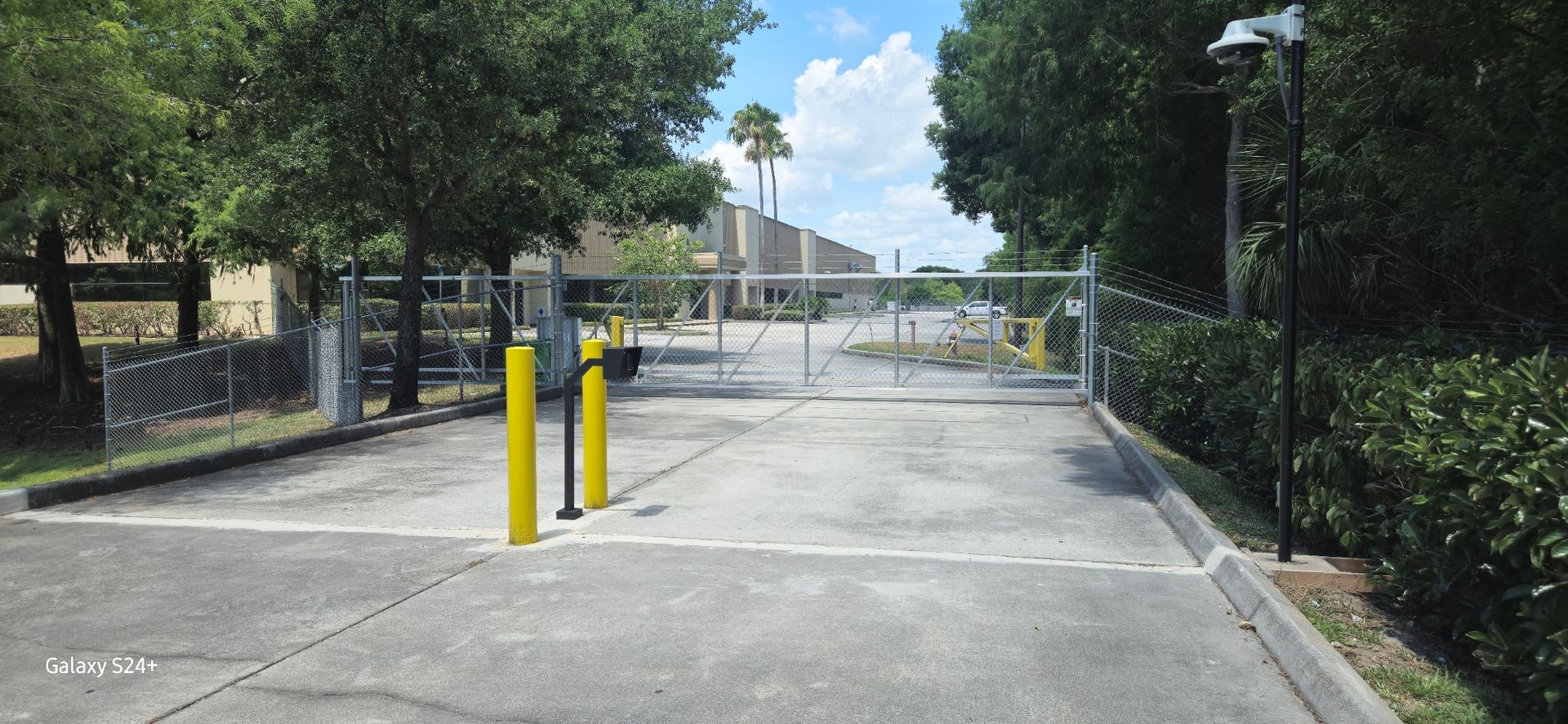 There is a gate in the middle of a parking lot.