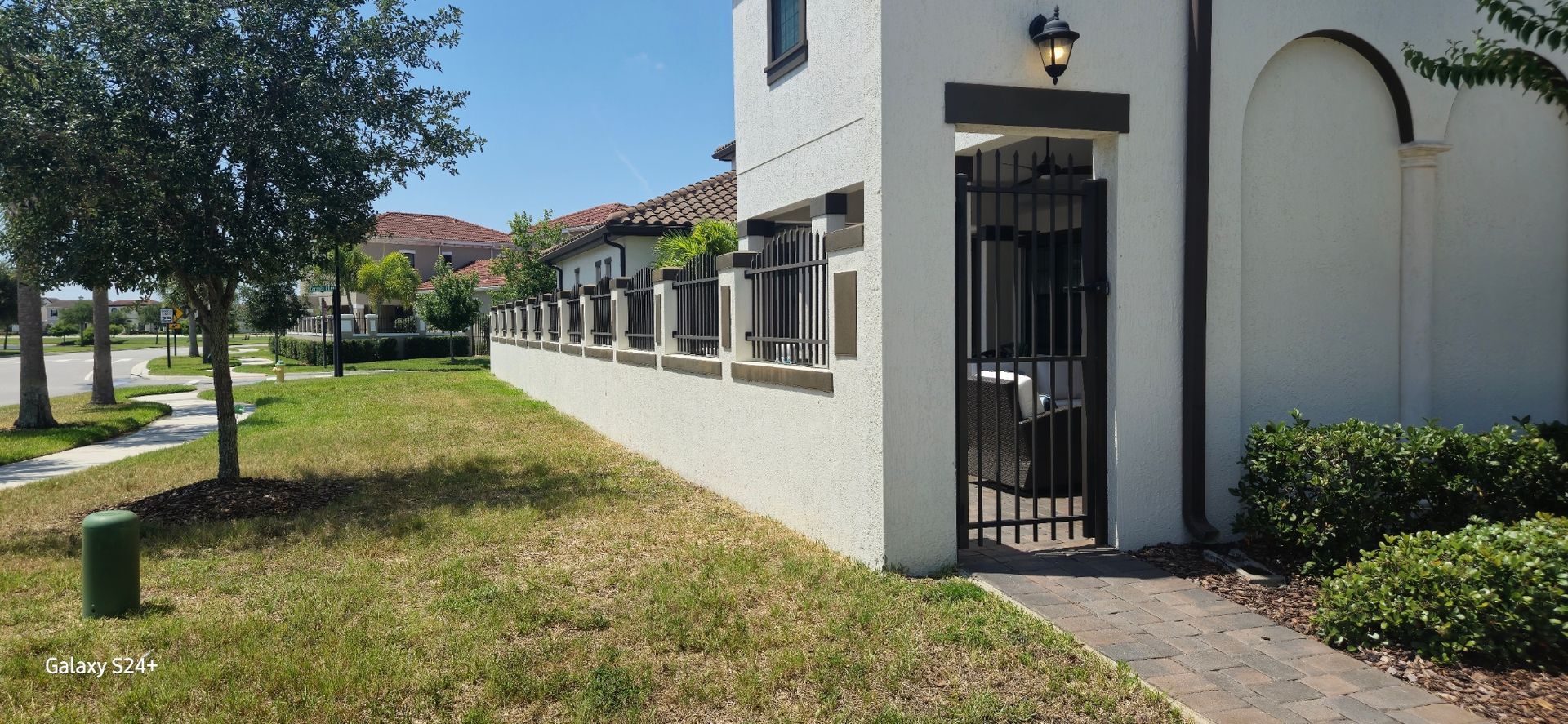 A white building with a gate in front of it.