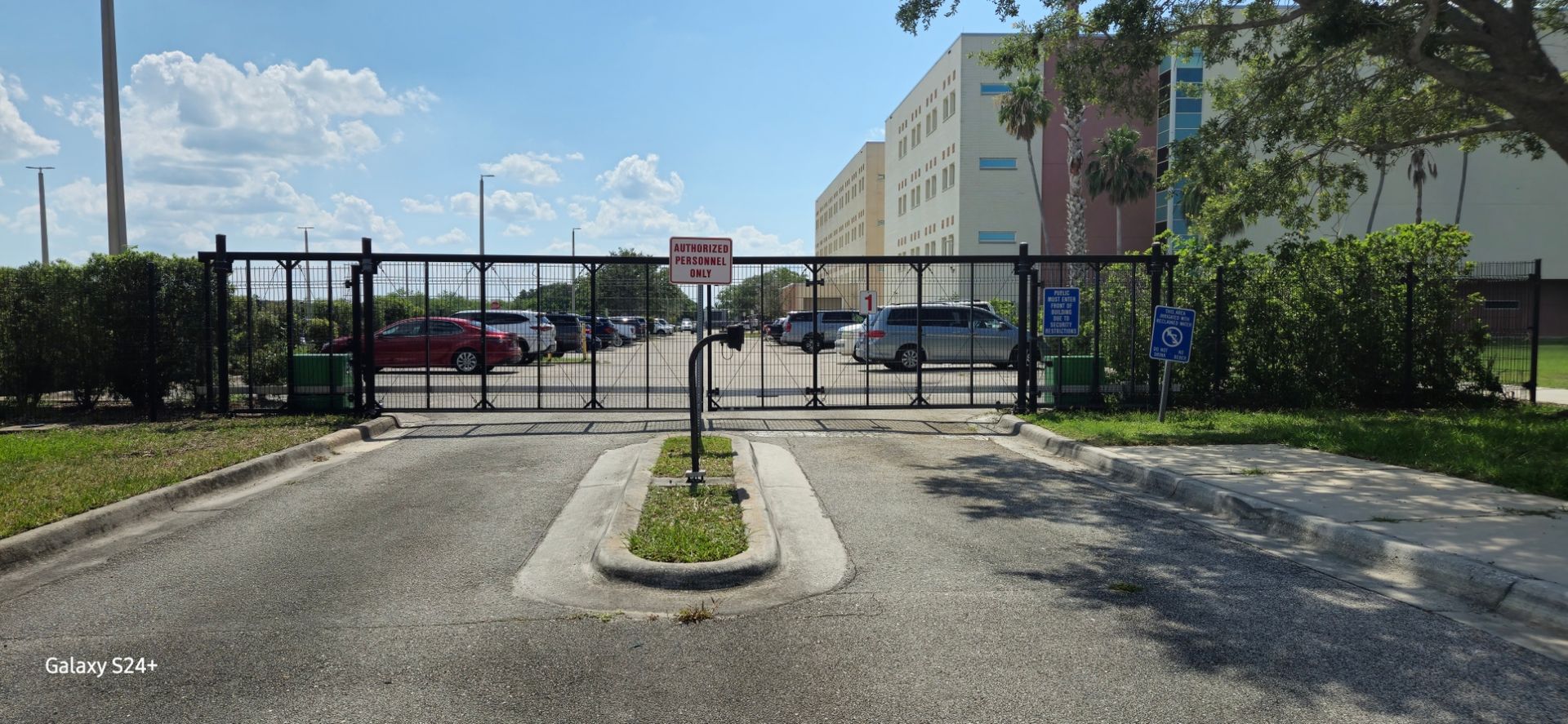 A gate is blocking the entrance to a parking lot.