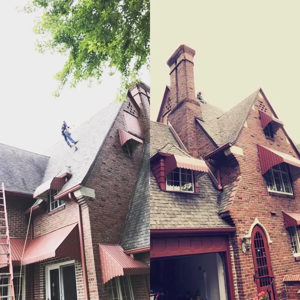 Red brick house with steep shingled roofs and chimneys under leafy trees