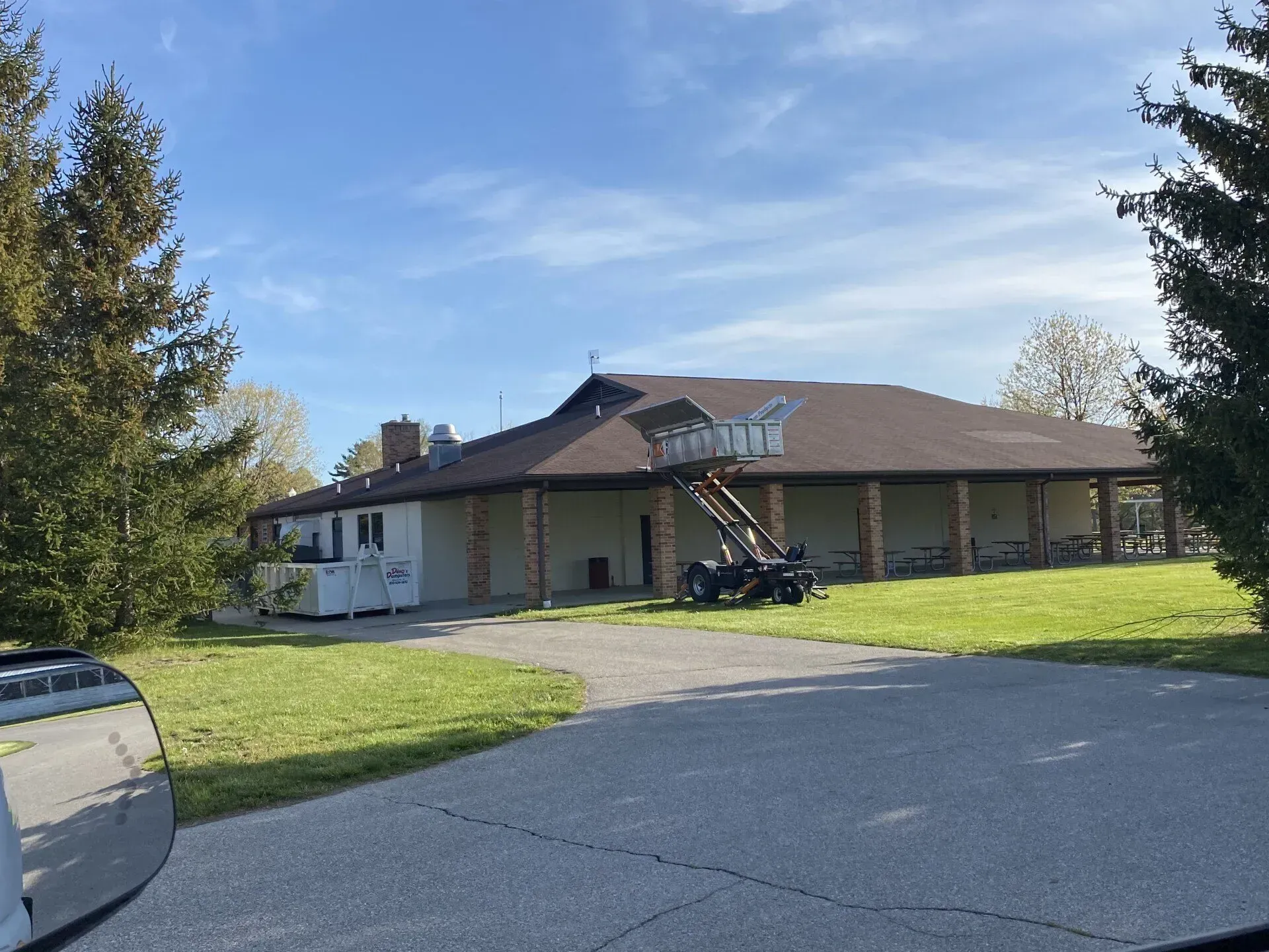 Single-story house with a brown roof, a lawn, and a driveway on a sunny day
