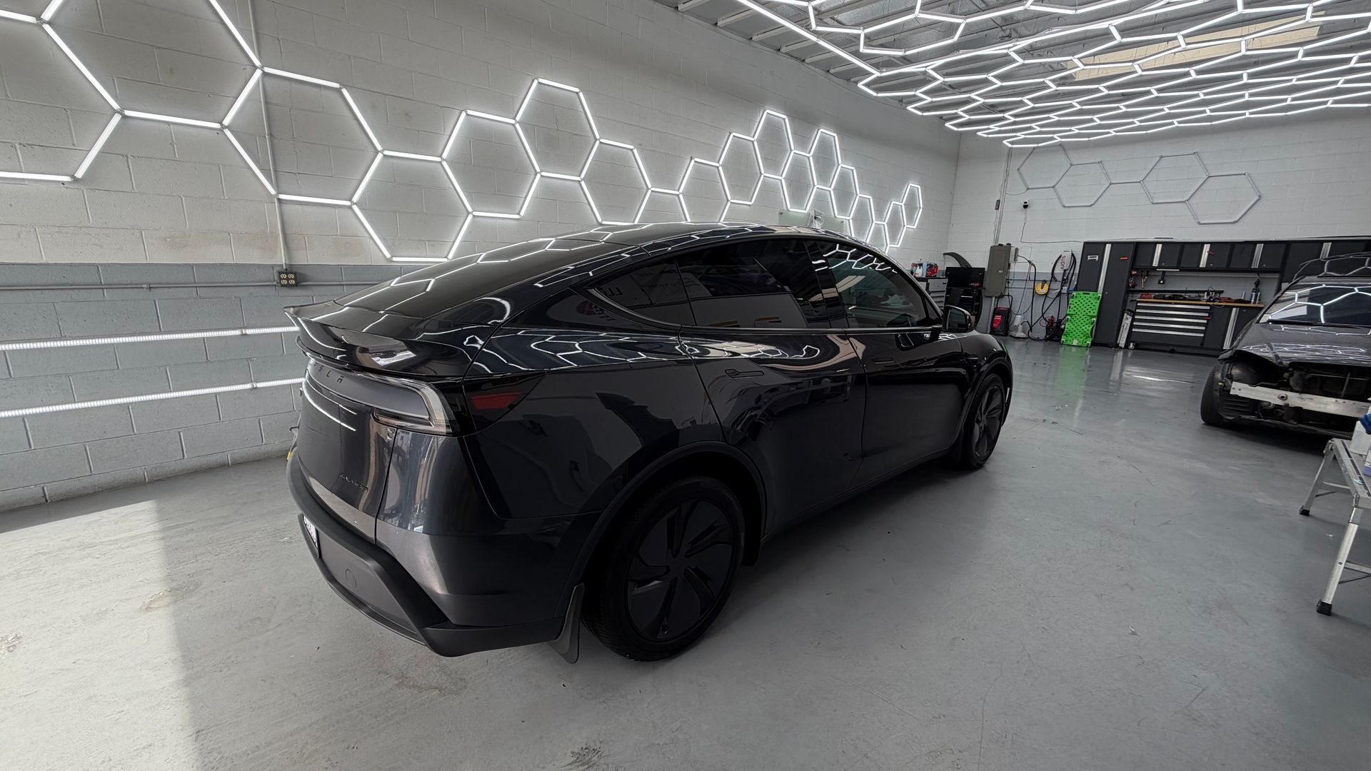 Black SUV in a bright showroom with hexagon wall lights