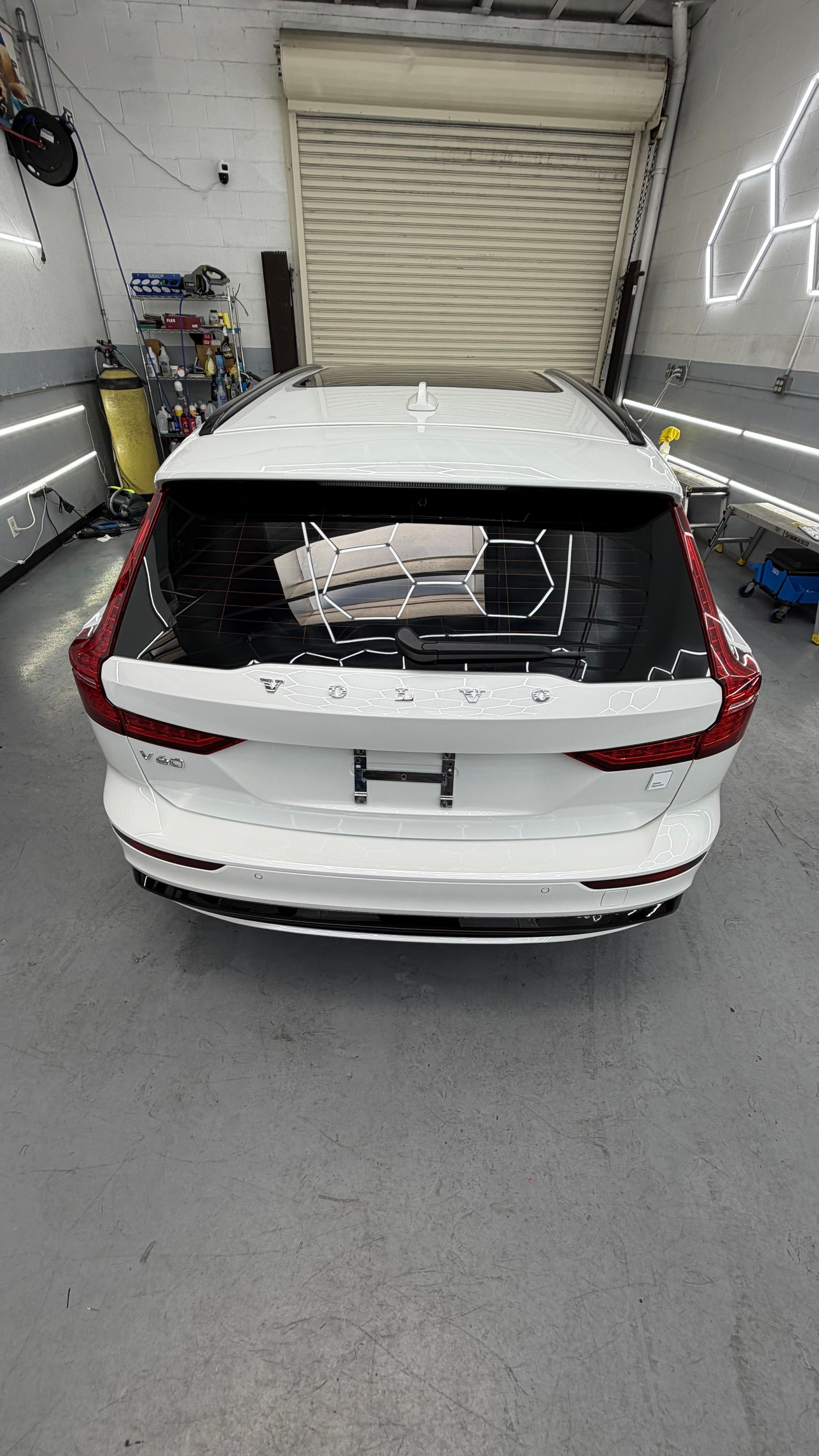 White SUV with shattered rear window in a garage, carrying boxes in the cargo area