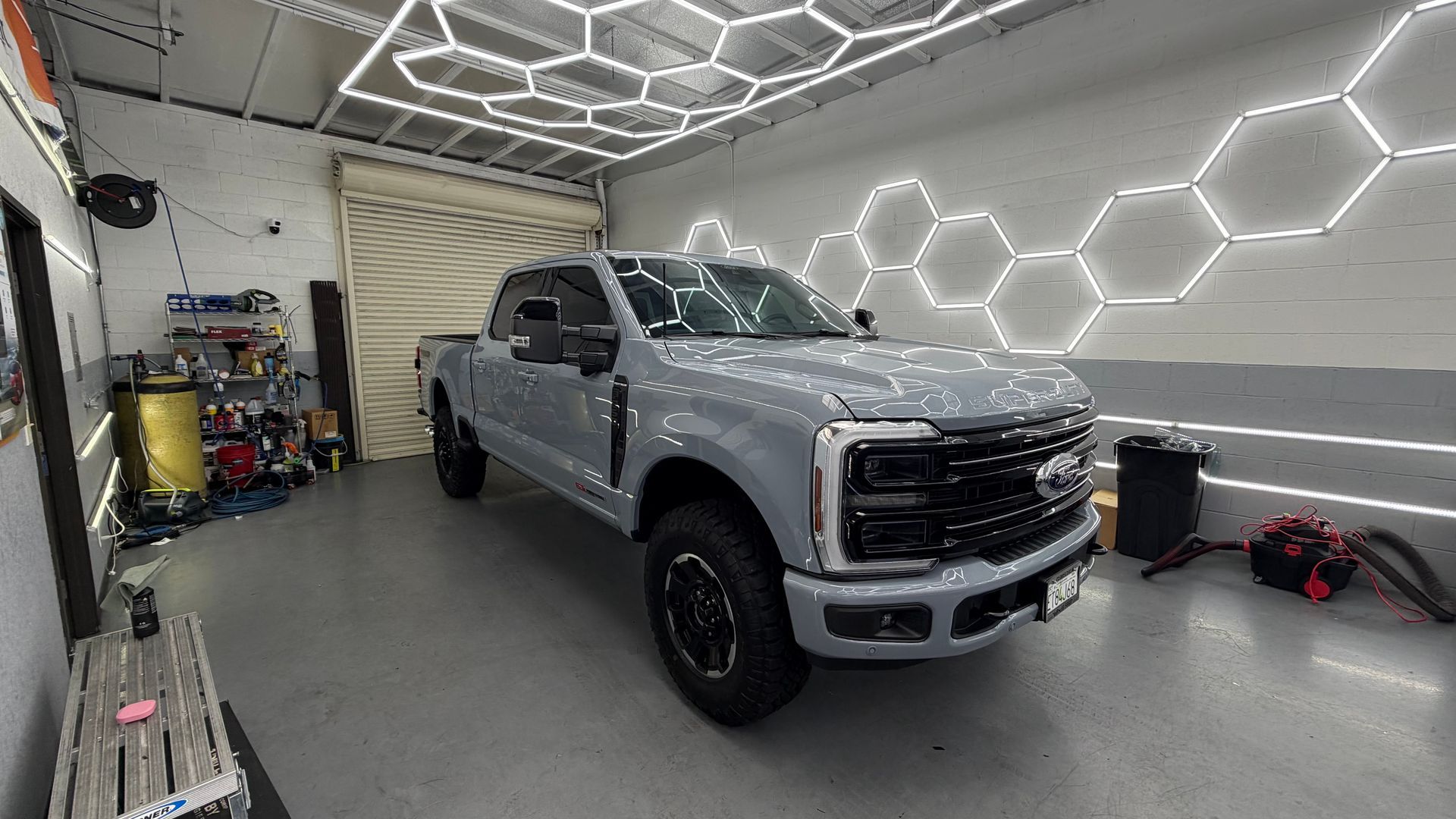 Silver pickup truck in a modern garage with hexagonal wall lights and a gray floor