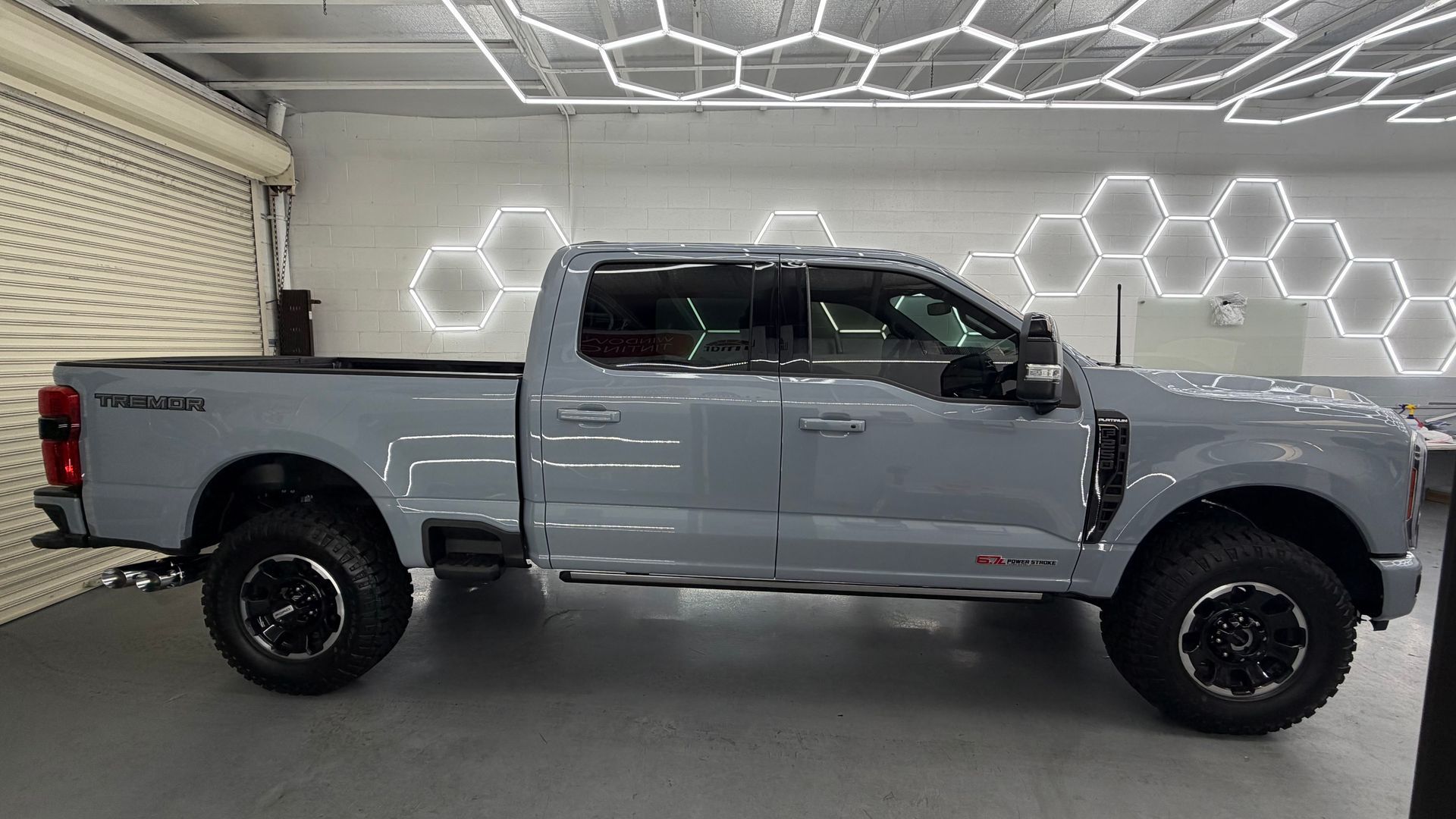 Silver pickup truck in a showroom with hexagonal illuminated wall panels