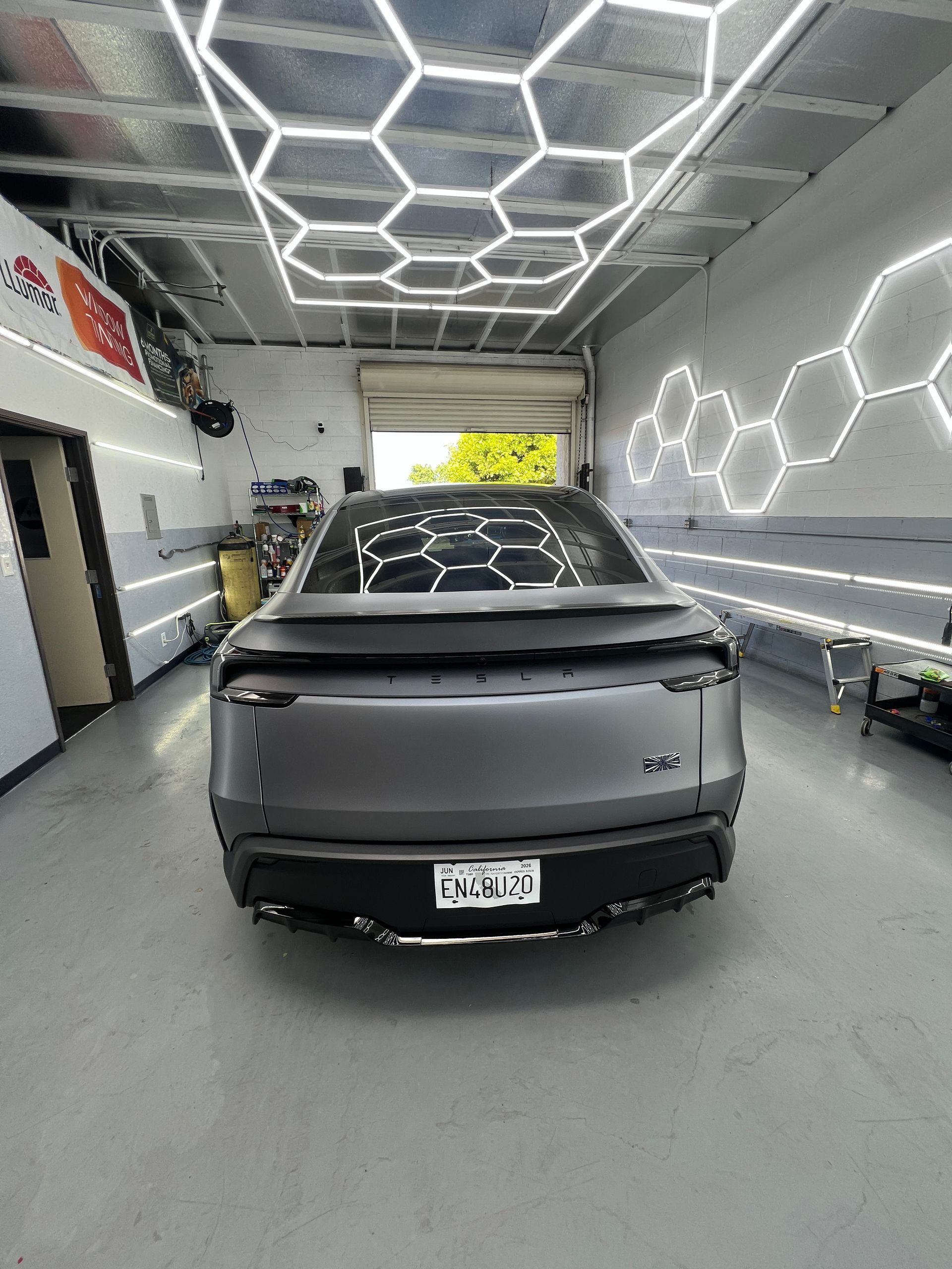Silver SUV parked inside a modern car detailing bay with geometric LED ceiling lights