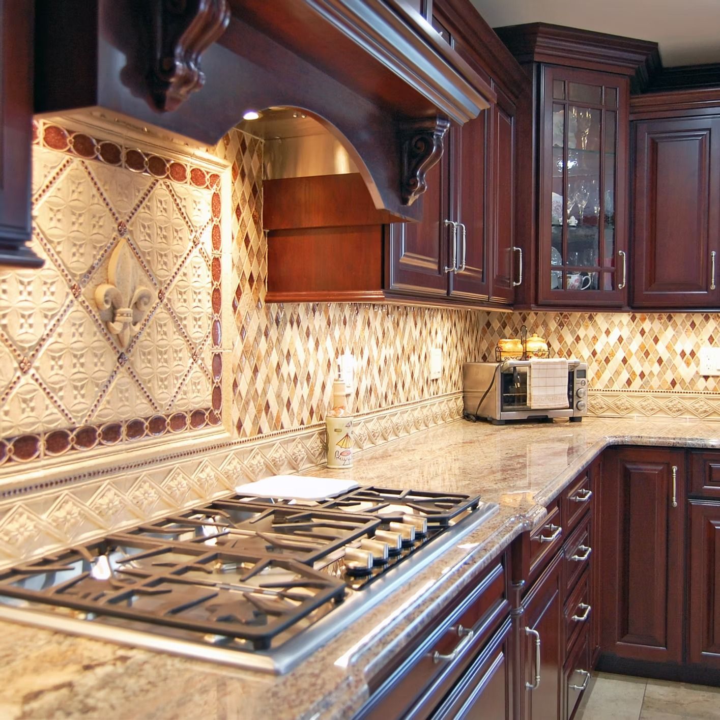 Dark wood kitchen with gas stovetop, tile backsplash, and granite countertops.