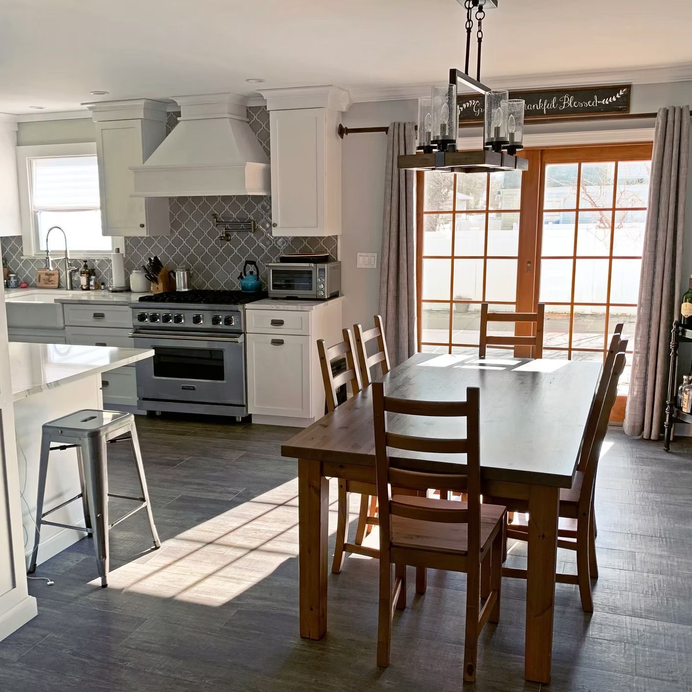Kitchen and dining area with a wooden table, chairs, and a stainless steel oven.