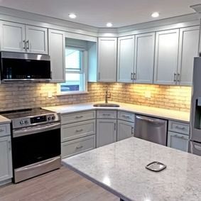 Kitchen with light blue cabinets, stainless steel appliances, and a white countertop.