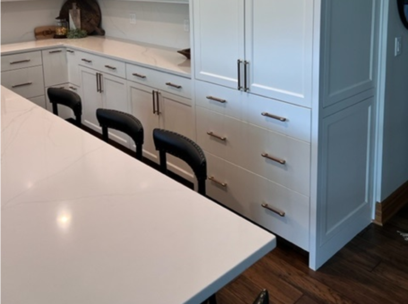 white countertop, black chairs, white kitchen cabinets