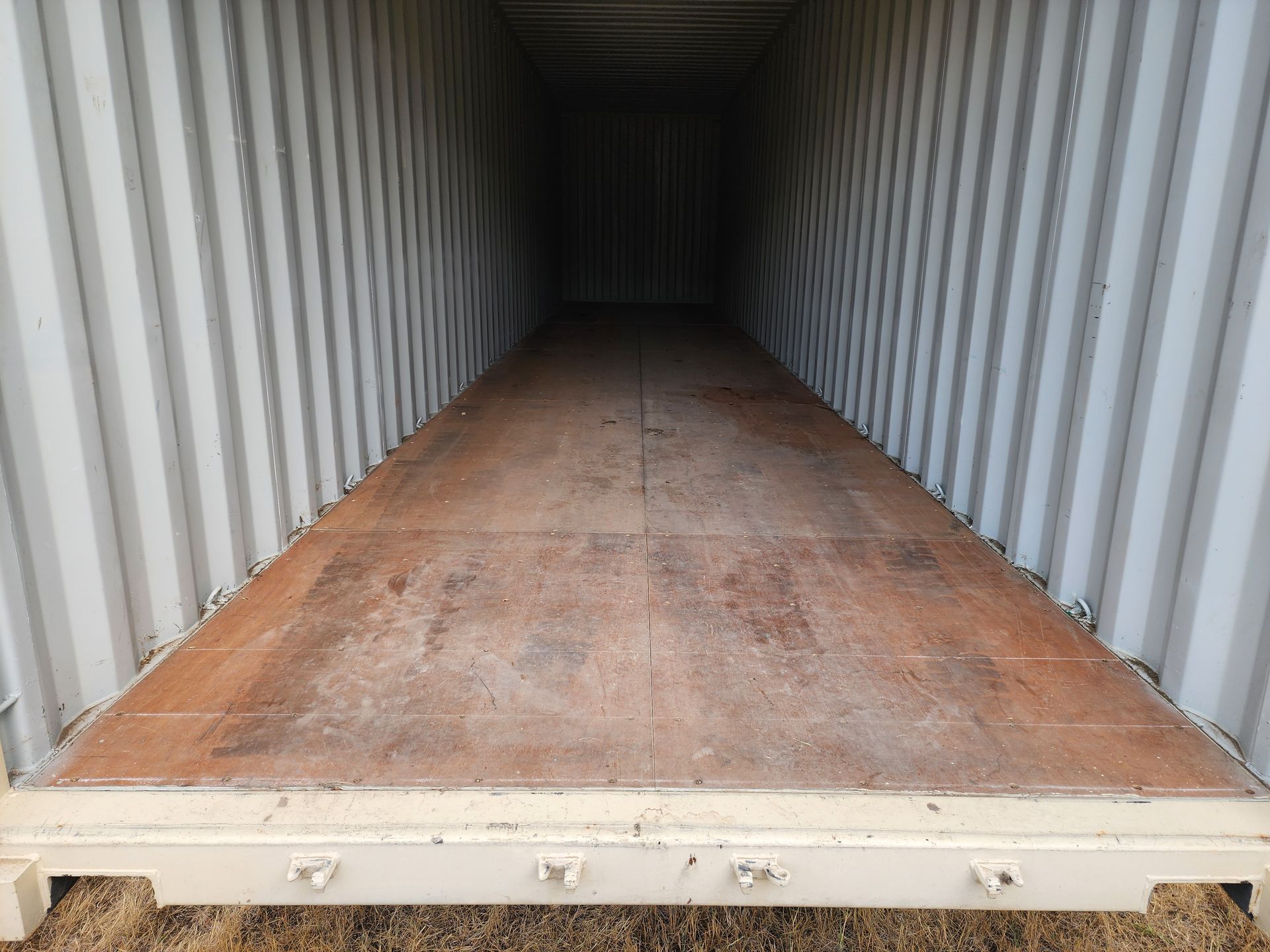 The inside of a shipping container with a wooden floor.