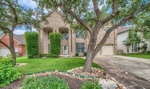 A large brick house with a tree in front of it.