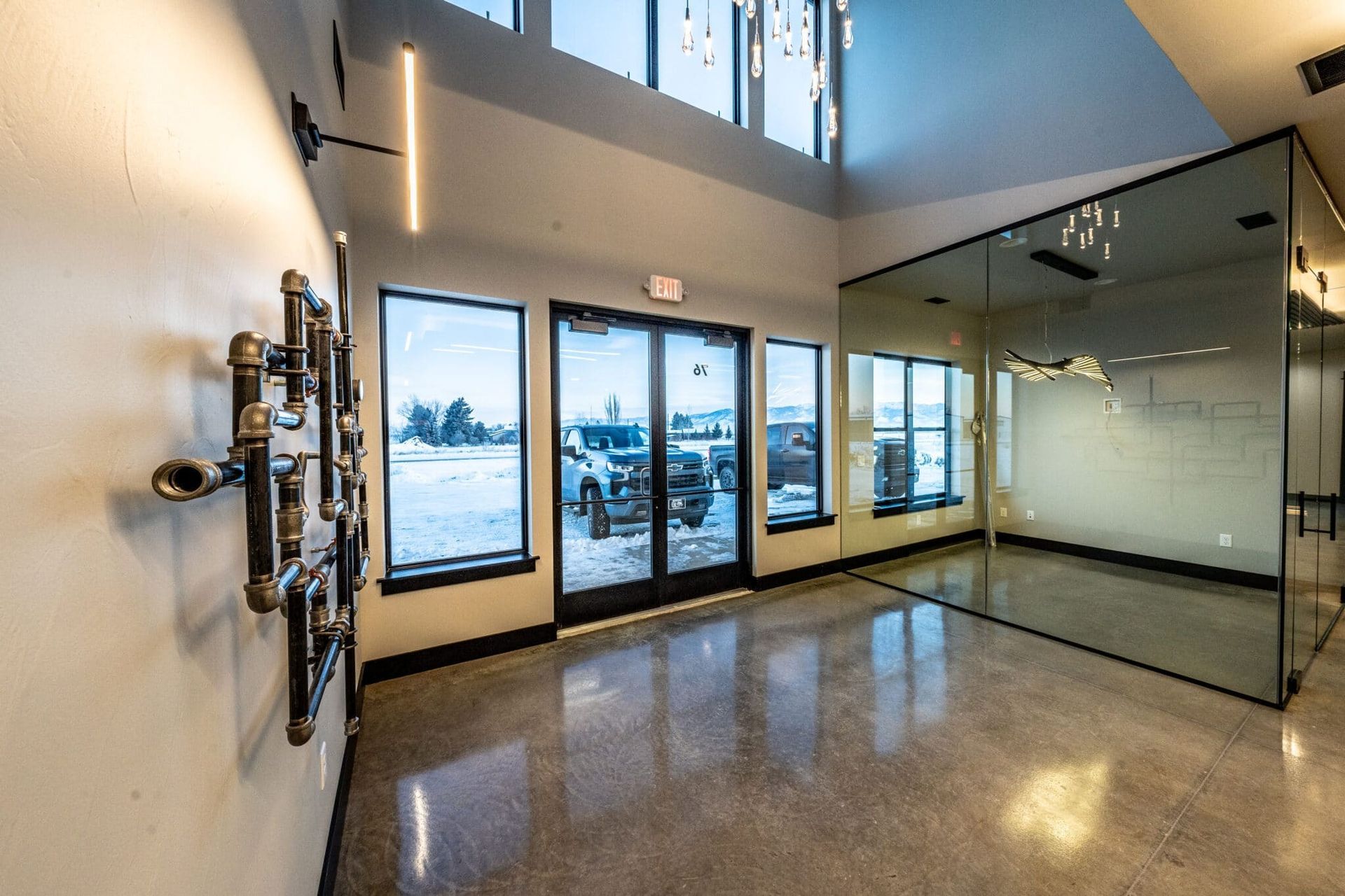 Interior lobby with glass wall, windows showing snow-covered ground, and industrial-style wall art.