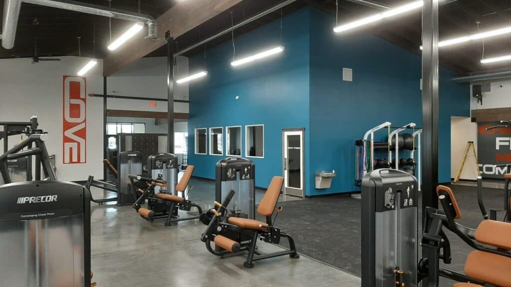 Gym interior with workout machines, teal walls, and 