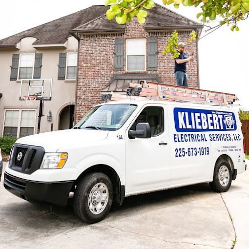 A kliebert electrical services truck is parked in front of a house