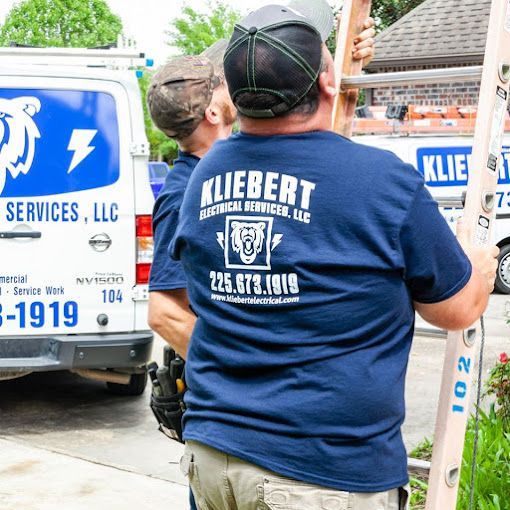A man wearing a blue shirt that says Kliebert Electrical Services.