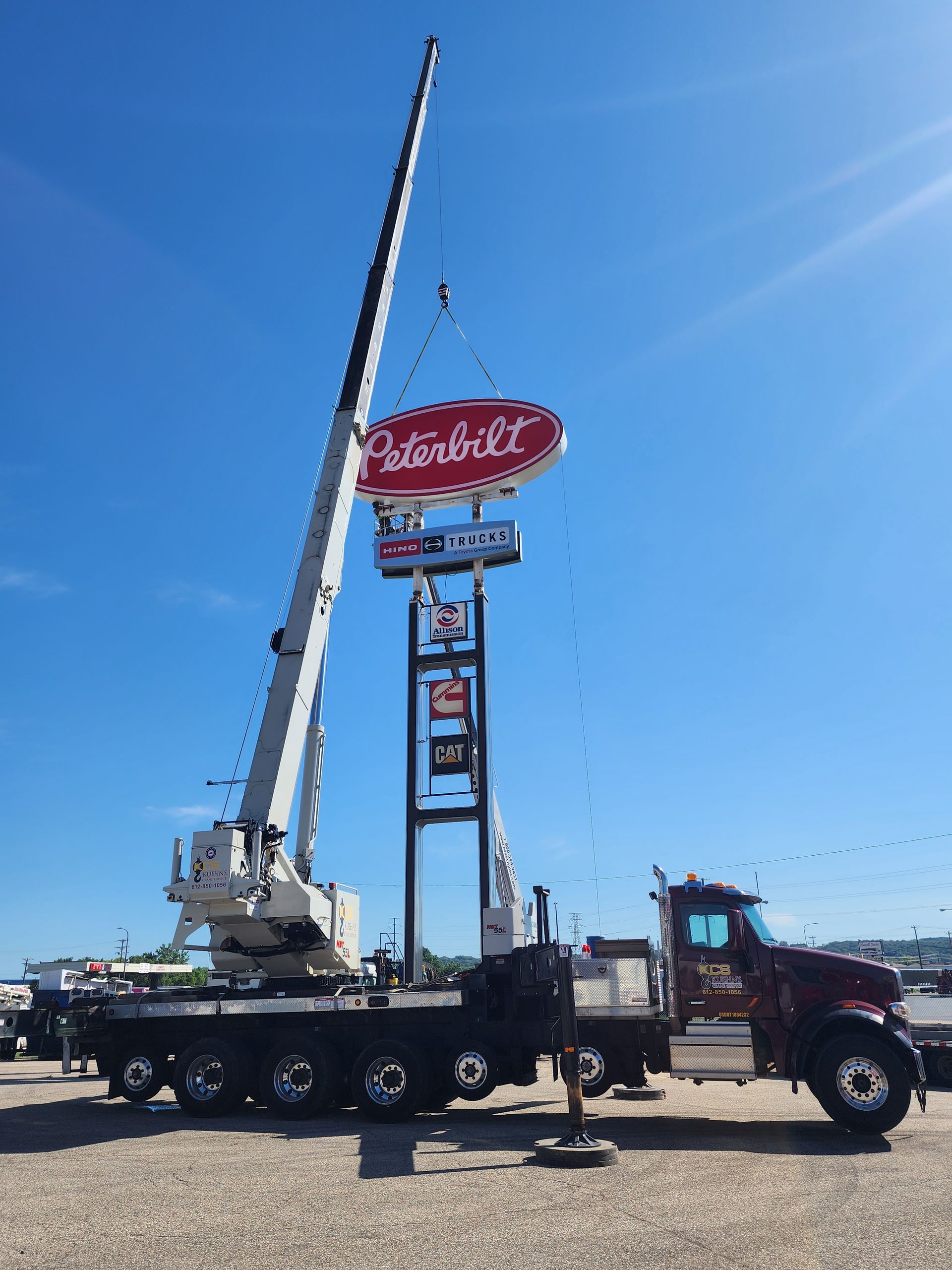 A peterbilt sign is being lifted by a crane.