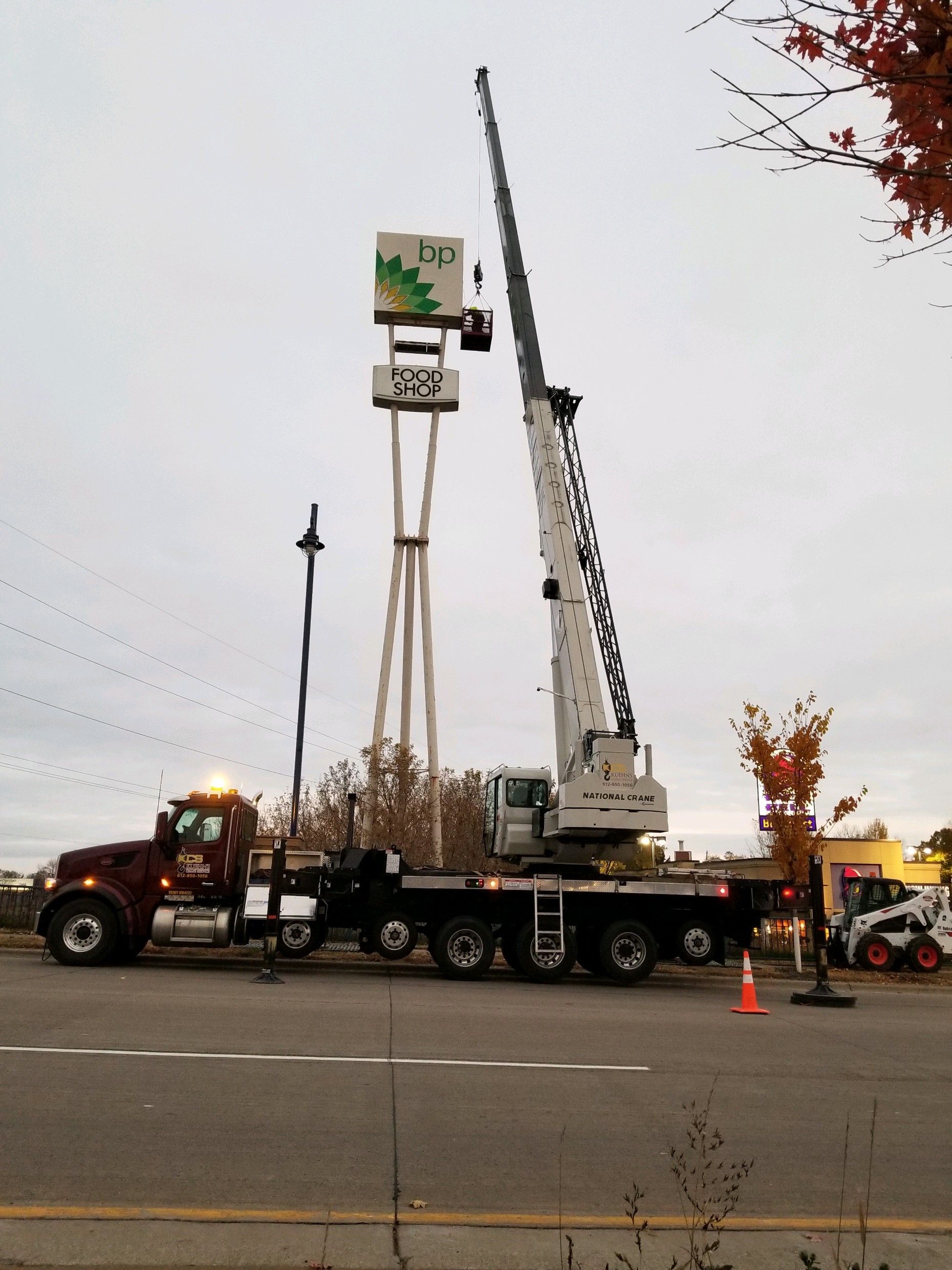 A truck with a crane attached to it is parked on the side of the road