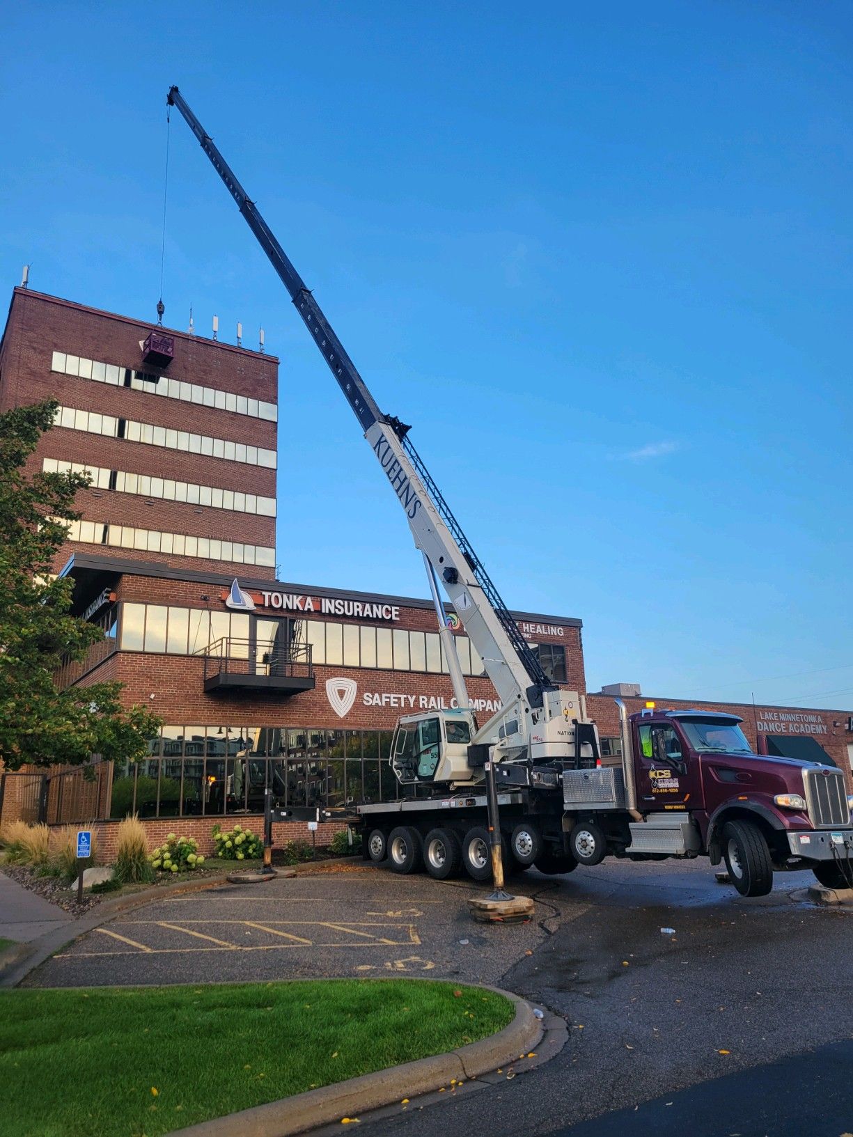 A large crane is sitting in front of a large building.