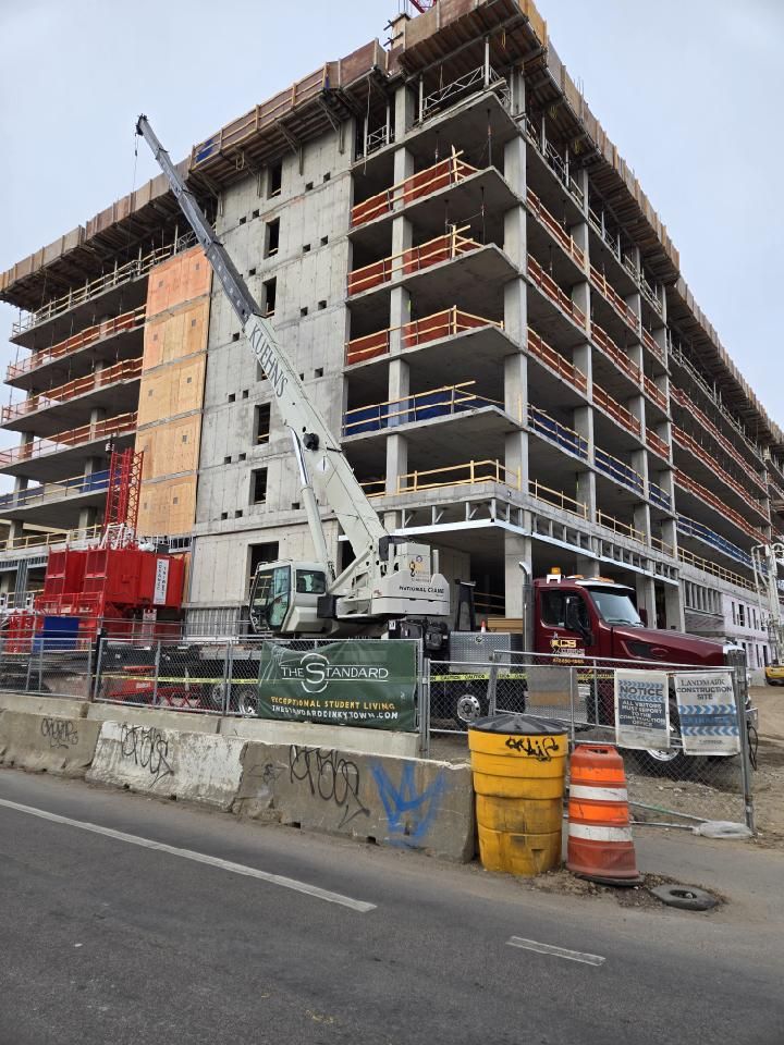 A large building under construction with a crane in front of it