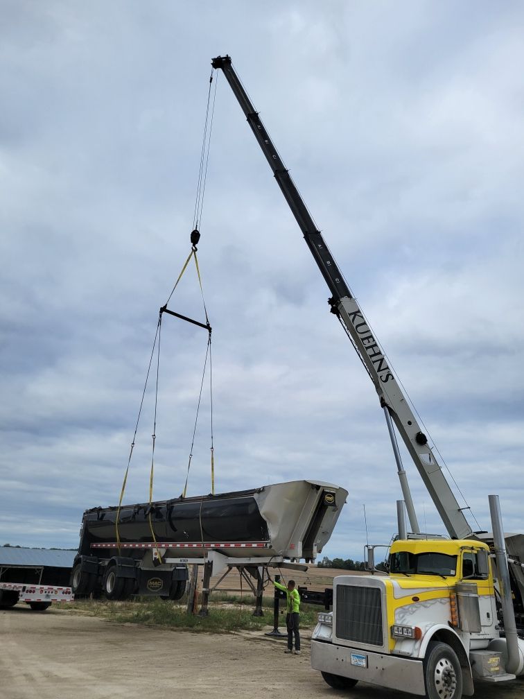 A truck is being lifted by a crane that says smith 's on it.