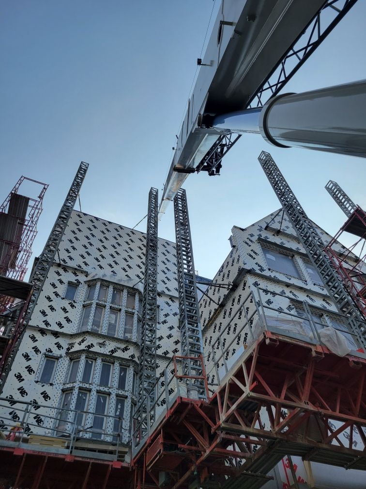 A large building is being built with a crane attached to it.