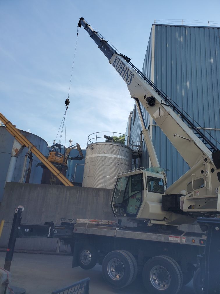 A large crane is sitting on top of a truck in front of a building.