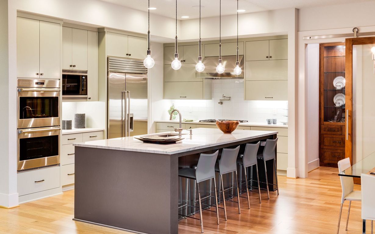 A kitchen with stainless steel appliances and a large island.