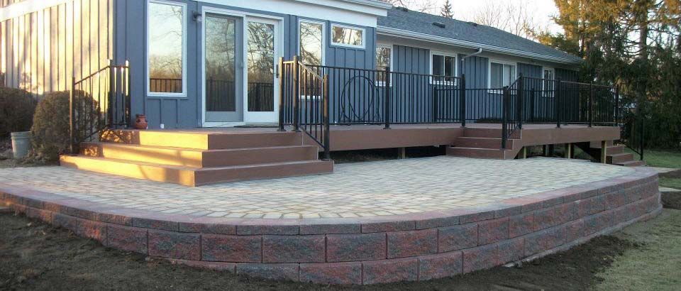 A blue house with a deck and stairs in front of it