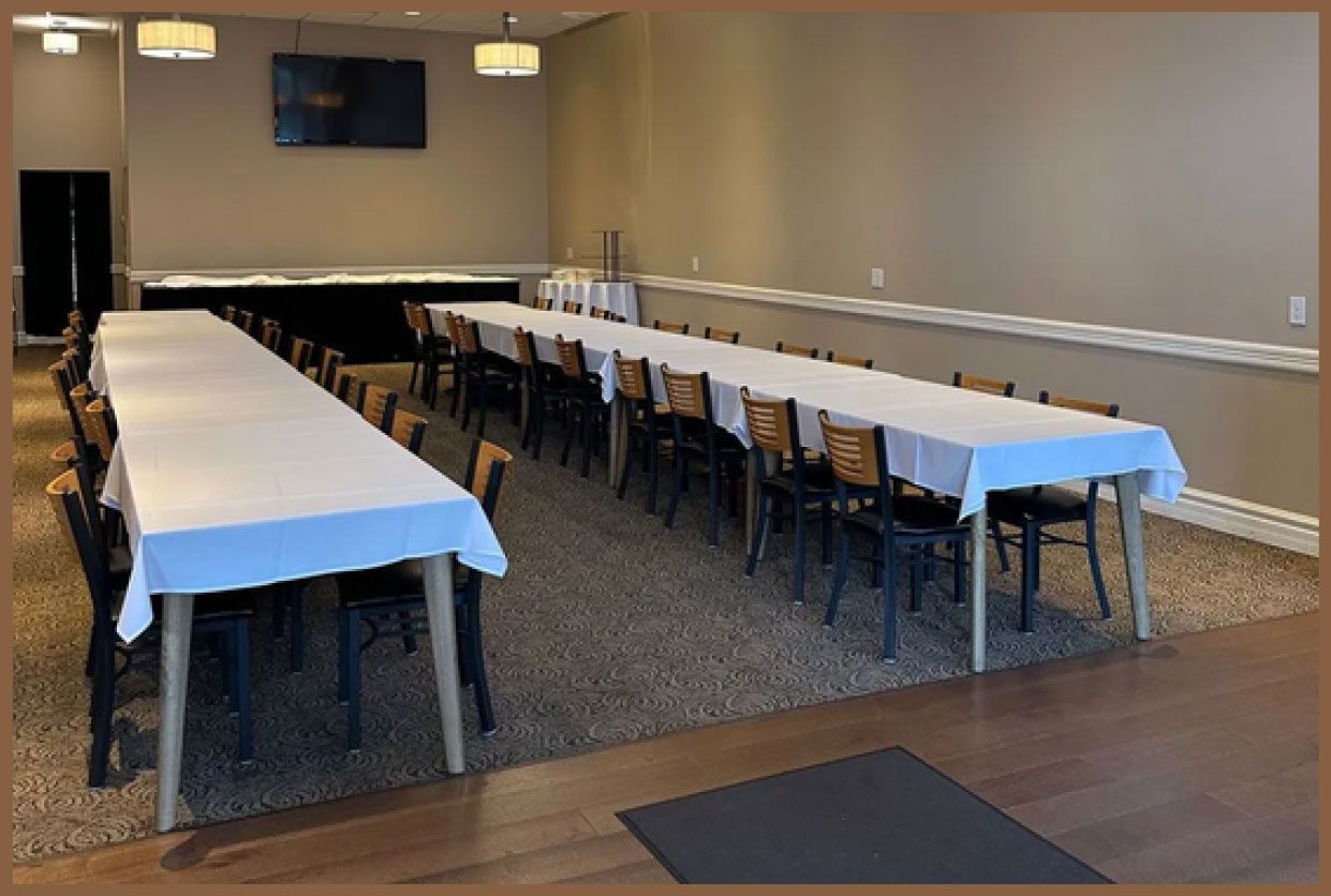 A large room with tables and chairs set up for a party.