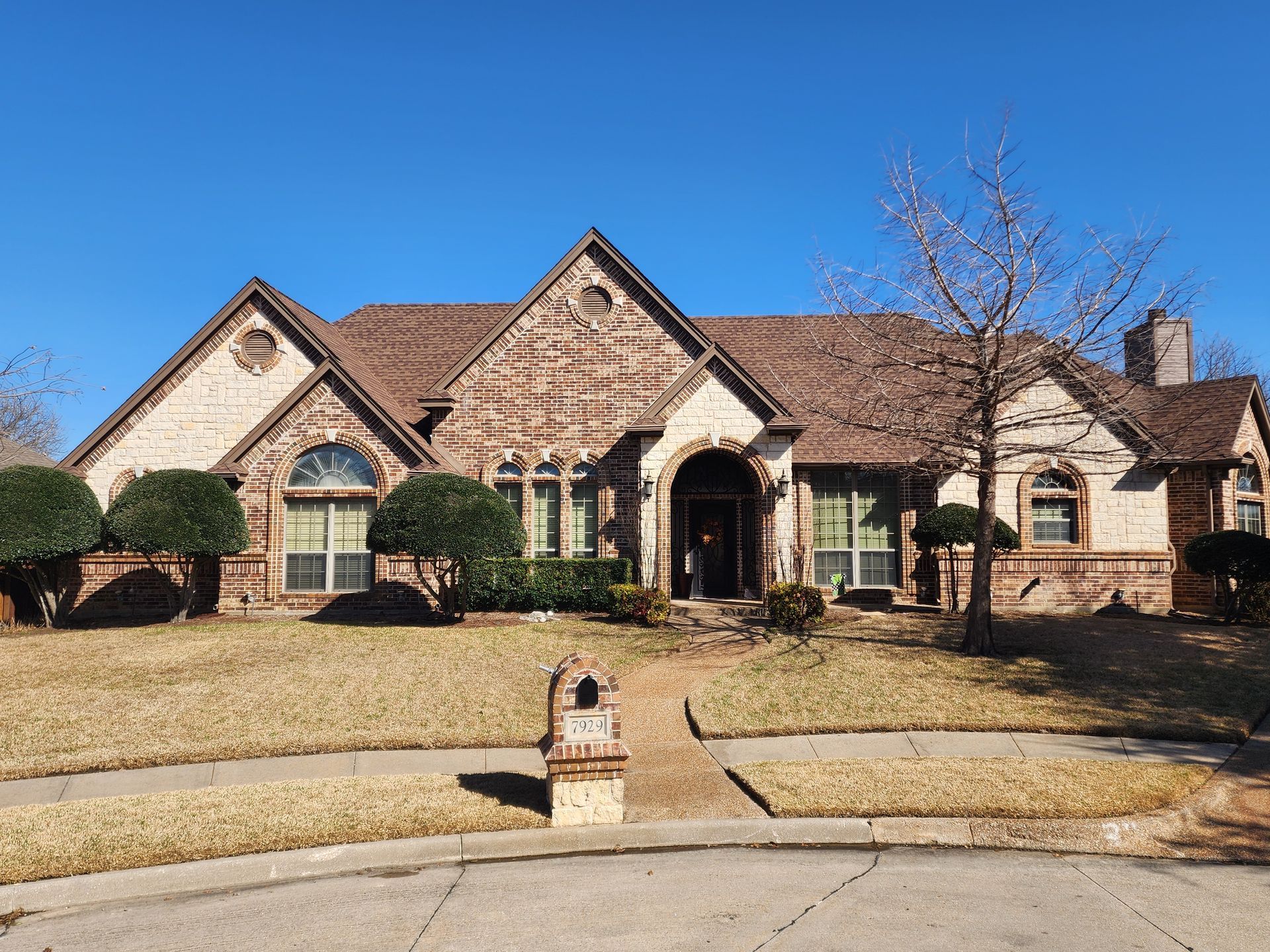 A large brick house with a brown roof