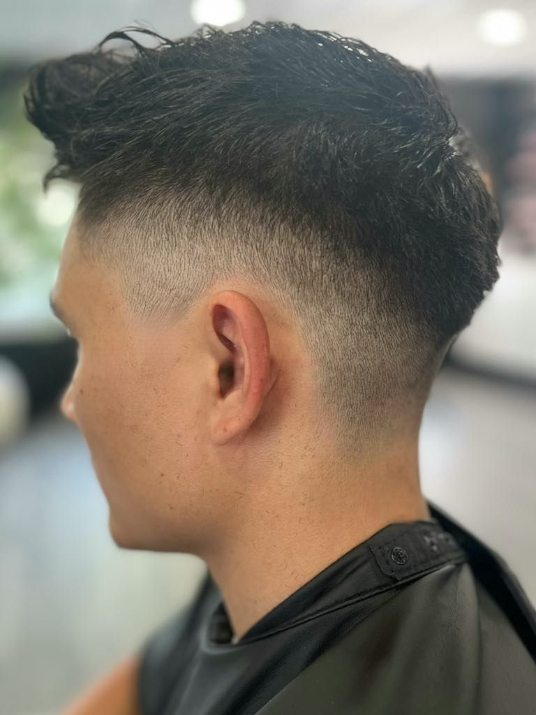 Man with dark hair, fade haircut, side profile.