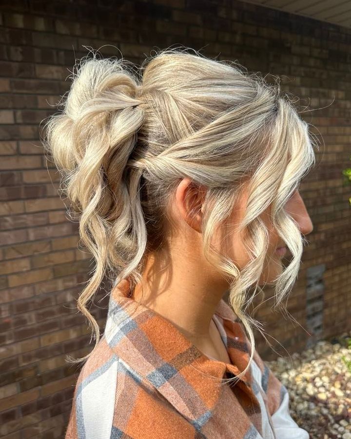 Blonde woman with updo hairstyle, side profile. She's outdoors wearing a plaid shirt, standing in front of a brick wall.