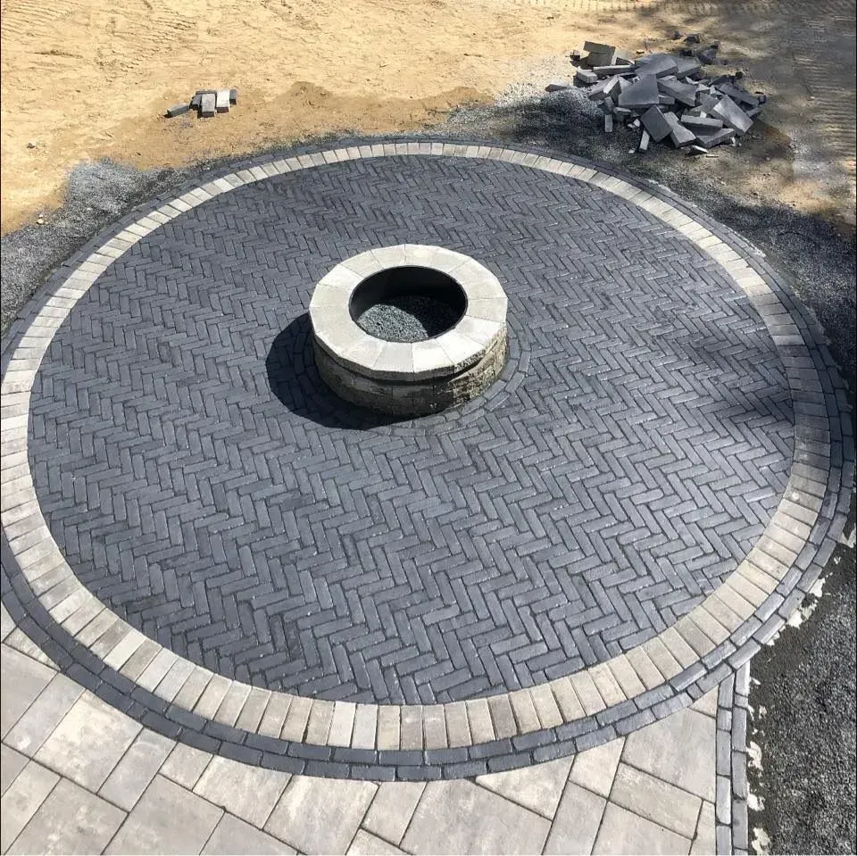 A fire pit is in the middle of a circle of bricks.