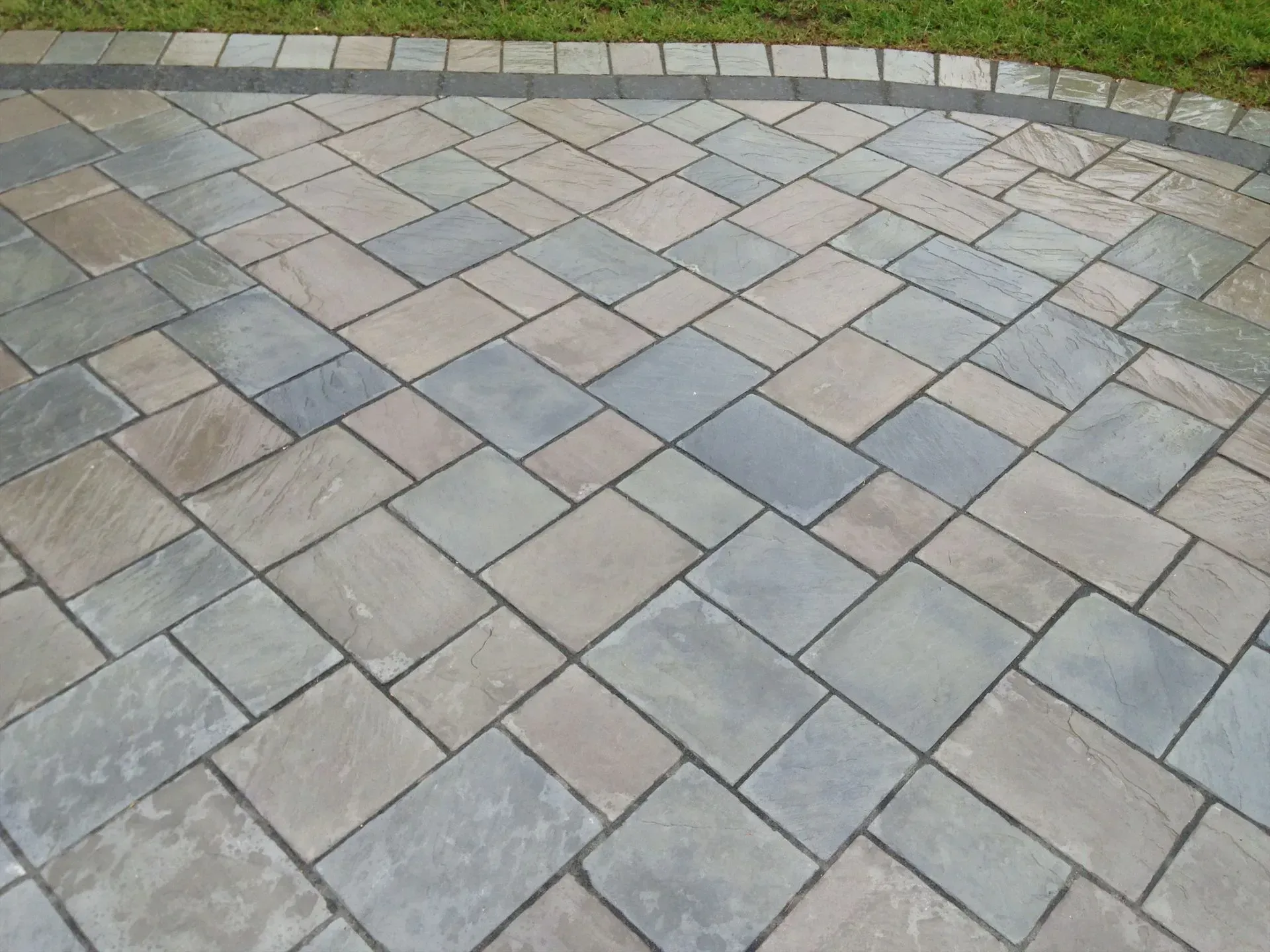 A patio with bricks in a herringbone pattern