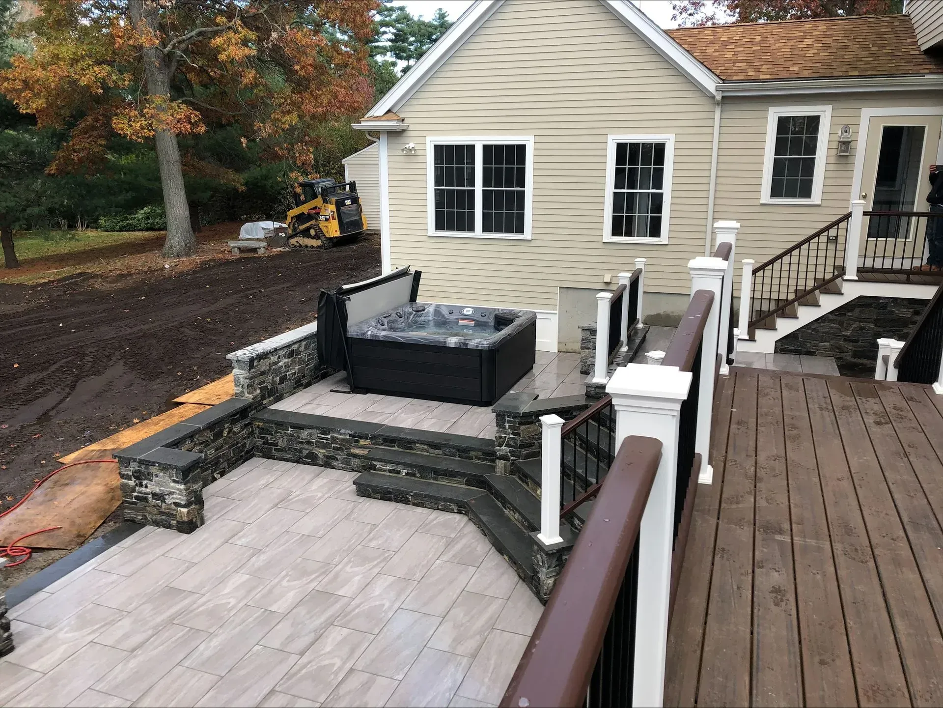 There is a hot tub on the deck of a house.